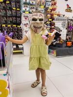 Podgorica, Monténégro - 14 août 2023. peu fille des stands dans une effrayant Halloween masque dans une magasin photo