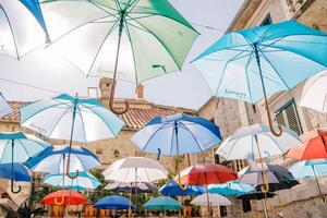 coloré parapluies pendre sur Cordes au dessus le rue près vieux Maisons photo