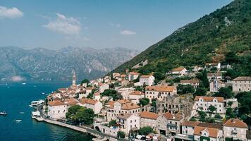 perast digue avec vieux Maisons et une Feu station à le pied de le montagnes. Monténégro photo