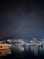 yachts amarré à le jetée avec gratte-ciel bâtiments sur le rive photo