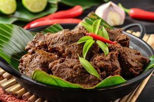 ai généré rendang du boeuf riches dans épices. rendang ensemble sur banane feuilles. indonésien nourriture photo