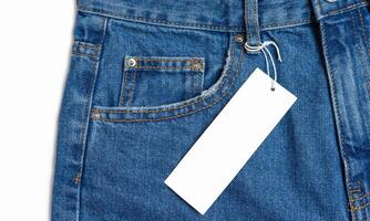 de face côté poche de bleu jeans un pantalon et prix étiquette fermer isolé sur blanc Contexte photo