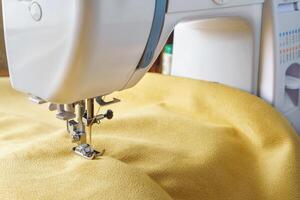 moderne couture machine avec Jaune velours en tissu proche en haut photo
