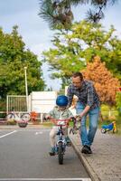 content père enseigne enfant fille à balade Publique bicyclette sur un de circulation terrain de jeux dans Prague, tchèque république, L'Europe . haute qualité photo