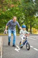 content famille père enseigne enfant fille à balade Publique bicyclette sur un de circulation terrain de jeux dans Prague dans tchèque république, L'Europe . haute qualité photo