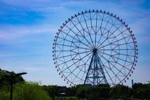 une ferris roue à le parc derrière le bleu ciel photo