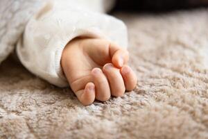 une la gauche main de en train de dormir asiatique bébé sur le tapis photo