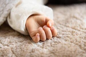 une la gauche main de en train de dormir asiatique bébé sur le tapis photo