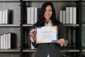 portrait sincère d'une belle jeune femme d'affaires caucasienne obtenant un certificat d'appréciation. concept d'entreprise photo