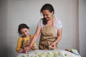 content mère nd fille cuisine Dumplings dans le rustique Accueil cuisine de une rural maison photo