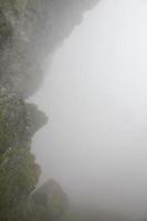 brouillard, nuages, rochers et falaises sur la montagne veslehodn veslehorn, norvège.