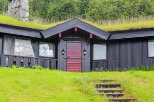 Cabane en bois noir avec toit envahi à hemsedal, norvège.