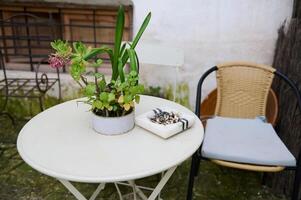 encore la vie avec marbre cendrier avec cigarette mégots sur table avec chaise dans jardin. le concept de poumon cancer maladies photo