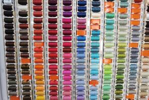 ensemble de multicolore fils pour couture - beaucoup différent couleurs couture fils arrangé dans une palette. loisir artisanat photo