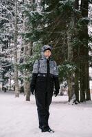 souriant Jeune femme permanent dans neigeux forêt photo