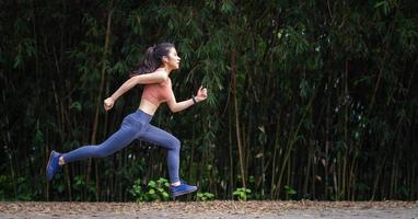 Jeune femme asiatique faisant de l'exercice dans le parc photo