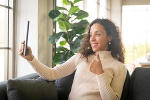 vidéoconférence femme latine sur tablette avec un sentiment de bonheur