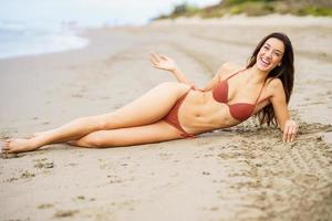 femme avec un beau corps en riant sur une plage tropicale en bikini photo