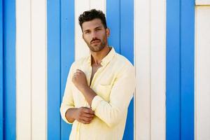 jeune homme, mannequin, posant devant un stand de plage. photo