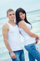 mec et une fille en jeans et t-shirts blancs sur la plage