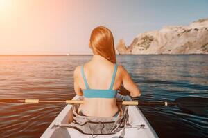 femme dans kayak retour voir. content Jeune femme avec longue cheveux flottant dans kayak sur calme mer. été vacances vacances et de bonne humeur femelle gens relaxant ayant amusement sur le bateau. photo