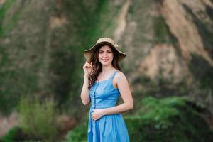 Jeune fille au chapeau de paille à large bord sur les pentes des montagnes photo