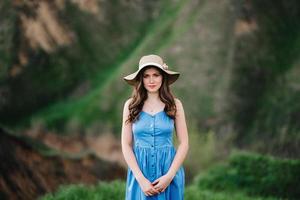 Jeune fille au chapeau de paille à large bord sur les pentes des montagnes photo