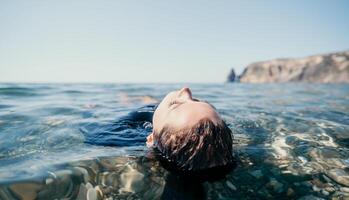 femme nager dans mer à coucher de soleil, flotte sur calme l'eau retour voir. concept de corps image et aptitude, profiter une serein plage. content femme avec parfait en forme corps jouit mer plage photo