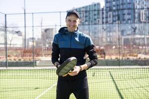 homme en jouant padel dans une vert herbe padel tribunal intérieur derrière le net photo