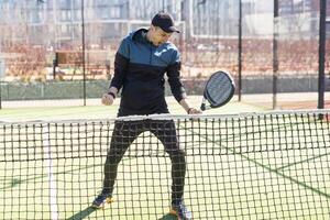 portrait de une européen homme padel tennis joueur en jouant sur le Extérieur tribunal photo