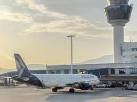 afines, Grèce - 20 août 2023. passager avion des stands près le Pont aérien dans de face de le aéroport bâtiment photo