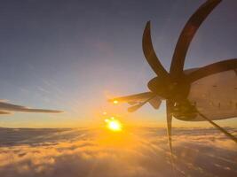 tournant hélice de un avion en volant dans le des rayons de le réglage Soleil photo