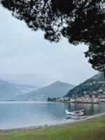 viens, Italie - 12 novembre 2023. petit hydroglisseur des stands sur le rivages de Lac viens, avec villas dans domaso dans le Contexte. Italie photo