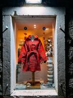 boudva, Monténégro - 25 décembre 2022. brillant rouge femmes manteau dans une magasin fenêtre photo
