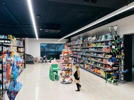 boudva, Monténégro - 25 décembre 2022. peu fille des stands près une jouet grille dans une supermarché. retour vue photo