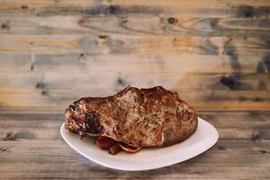 cuit rôti du boeuf avec des légumes mensonges sur une assiette sur une en bois table photo