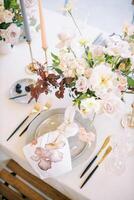 noué serviette de table mensonges sur une assiette près une bouquet de fleurs sur une ensemble tableau. Haut vue photo