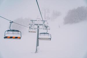 quadruple télésiège monte au dessus neigeux forêt à brumeux Montagne photo