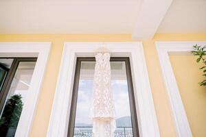 blanc mariage robe avec une train pendaison sur une cintre sur le balcon photo