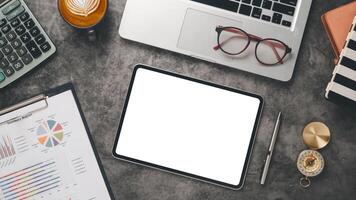 un organisé professionnels bureau avec une tablette, ordinateur portable, calculatrice, et rapport, prêt pour un efficace travail session. photo