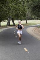 caucasien adolescent fille fonctionnement sur bicyclette chemin dans parc photo