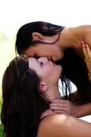 asiatique américain et caucasien femmes embrasser extérieur photo