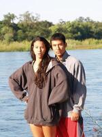 homme et femme permanent à rivière dans brillant lumière du soleil photo