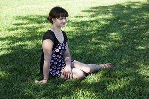 Jeune caucasien femme séance sur herbe ombre photo