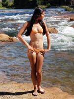 maigre femme Orange bikini permanent rivière banque photo