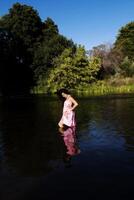 Jeune Japonais américain femme permanent dans rivière photo
