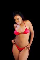 africain américain femme permanent dans rouge bikini photo