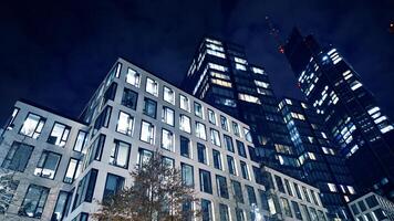 Bureau bâtiments par nuit. nuit architectural, bâtiments avec verre façade. moderne bâtiments dans affaires district. concept de économie, financier. photo