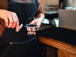 gros plan sur un café barista à la main faisant du café avec des presses manuelles du café moulu à l'aide d'un sabotage au café photo