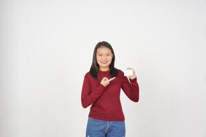 Jeune asiatique femme dans rouge T-shirt montrant Vide carte isolé sur blanc Contexte photo